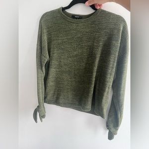 Green sweater with bow sleeves.